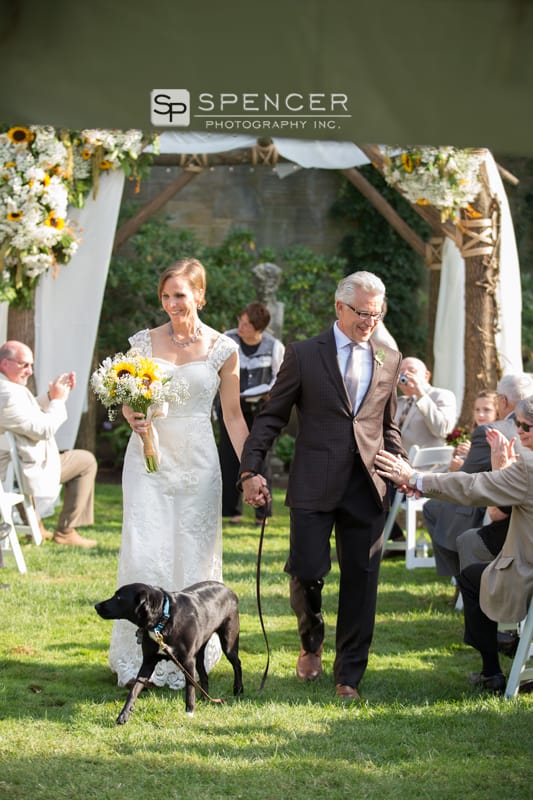 bride and groom walking down aisle with dog
