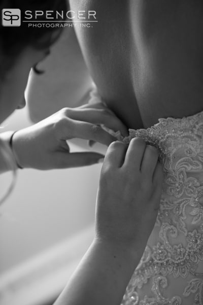 bride getting wedding dress buttoned