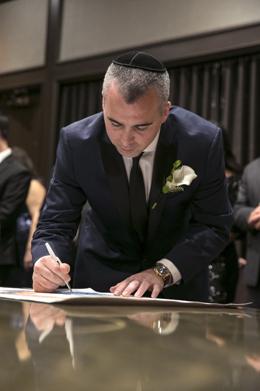  groom signing ketubah