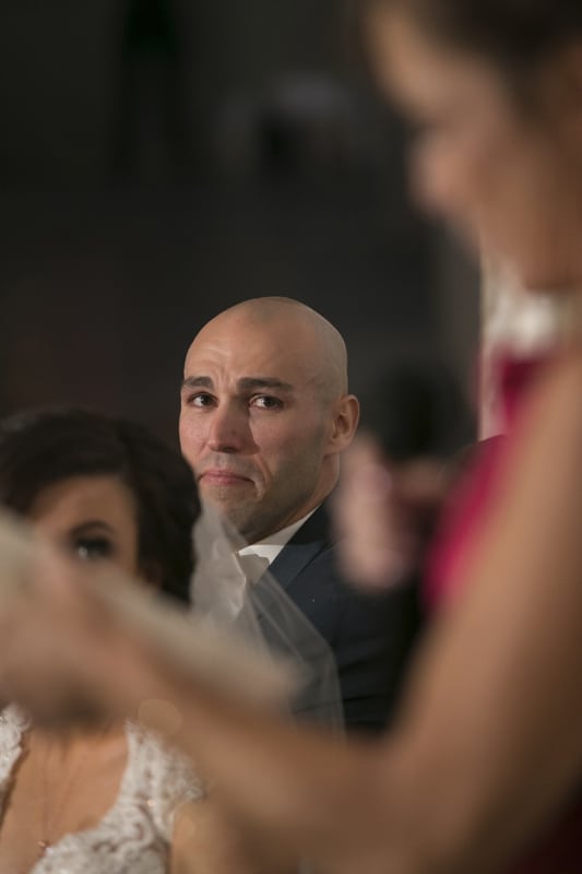 groom watching wedding reception speech 
