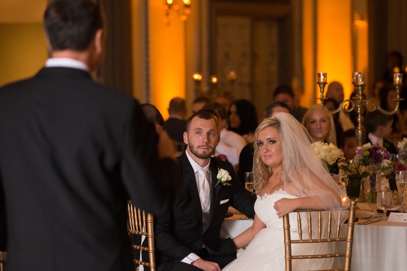 bride and groom watching dad give speech