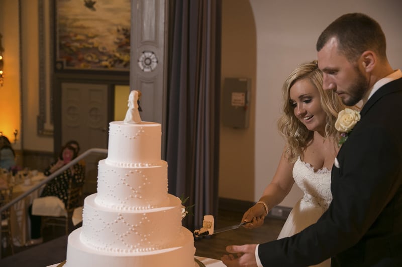 cutting the cake at tudor arms wedding reception