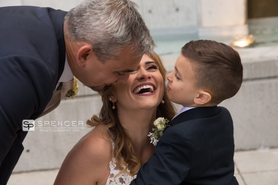 groom and son kissing bride on wedding day