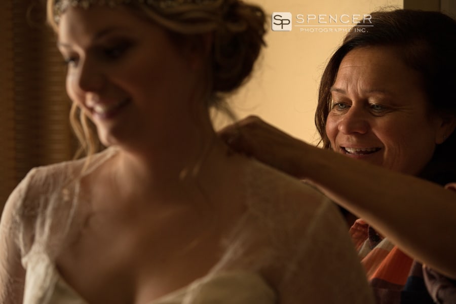 mom helping daughter with her wedding dress