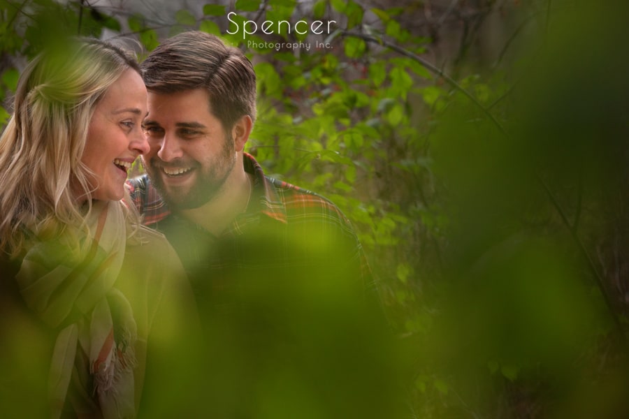couple laughing at engagement session in the woods in akron
