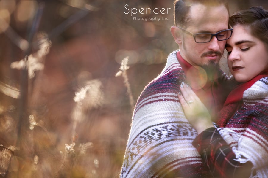 couple wrapped in blanket hugging for their engagement pictures in cleveland