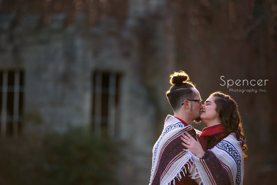 engaged couple kissing in front of squires castle