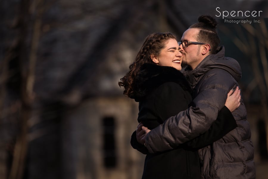 man kissing woman at engagement session at squires castle
