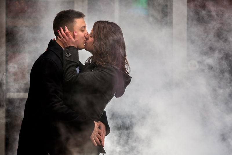 couple kissing in smoke during engagement pictures in downtown Cleveland 