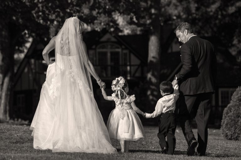 bride and groom walking with flower girl