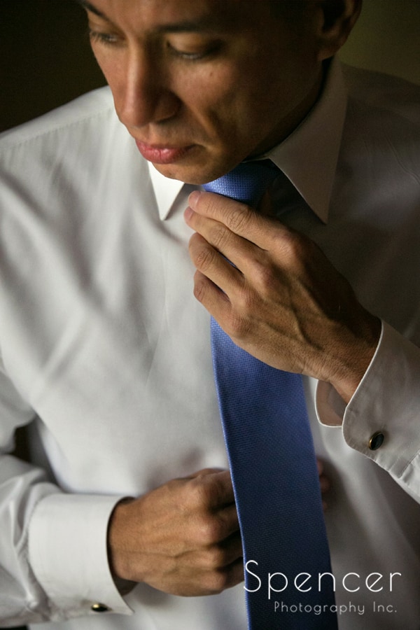 groom adjusting tie