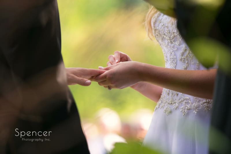 bride putting wedding ring on groom