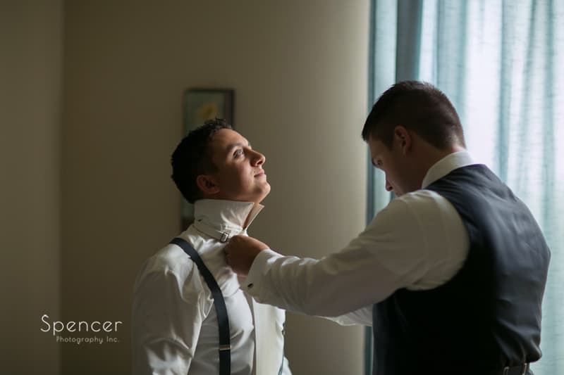 best man helping groom dress for his wedding