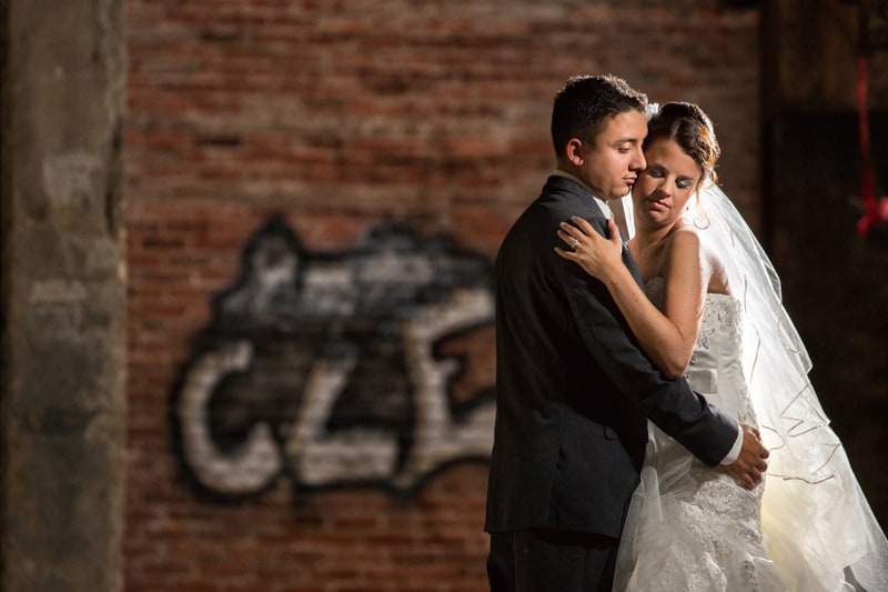 bride and groom hugging in warehouse in Cleveland