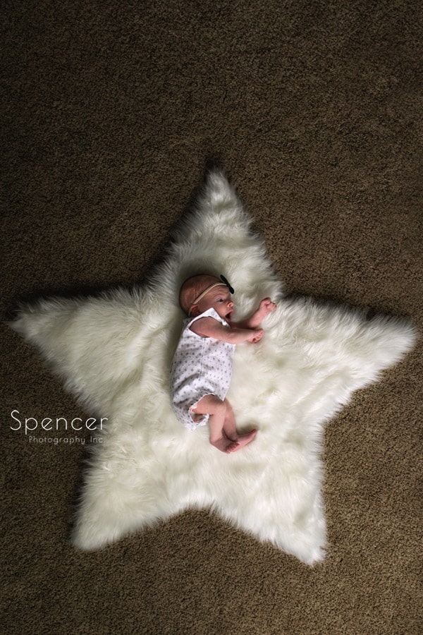 newborn baby laying on star carpet