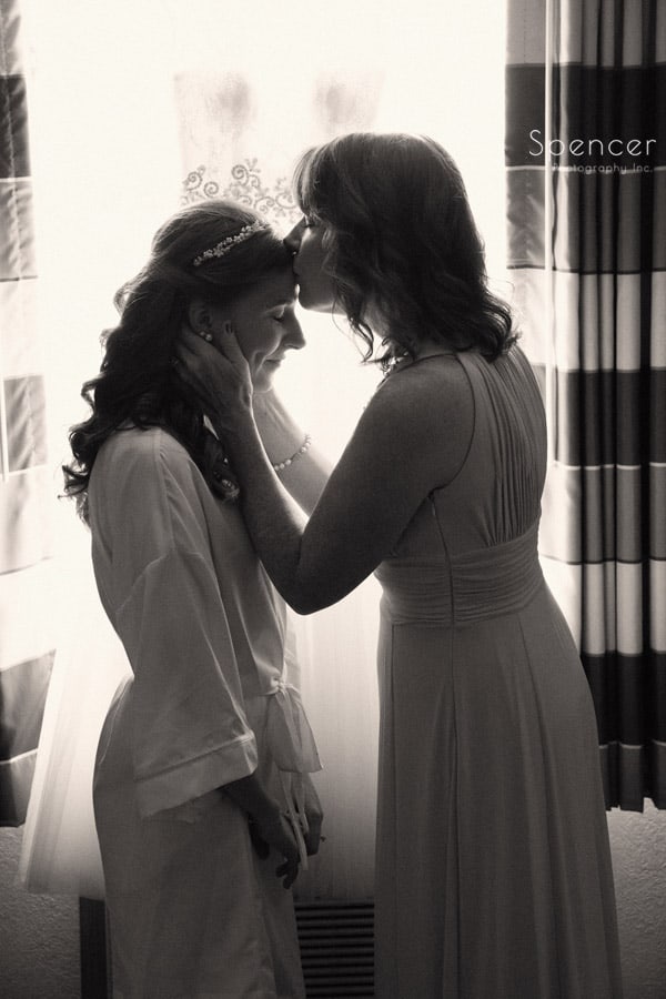  mom kissing bride on her wedding day