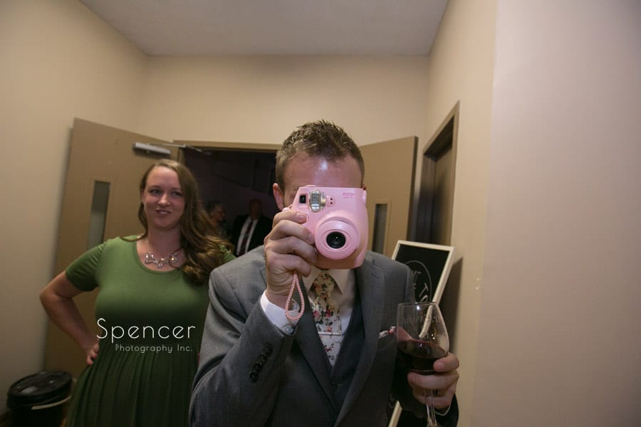 groom using polaroid camera