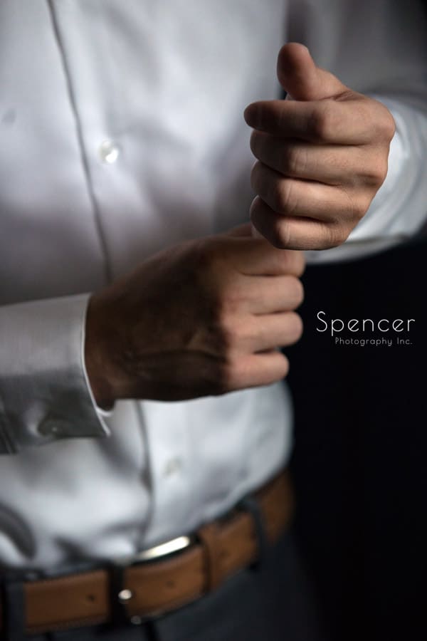  groom buttoning his sleeve on his wedding day