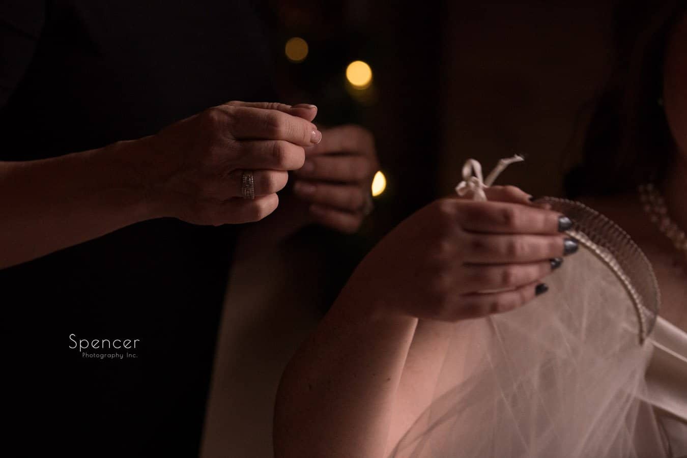 bride handing veil to helper