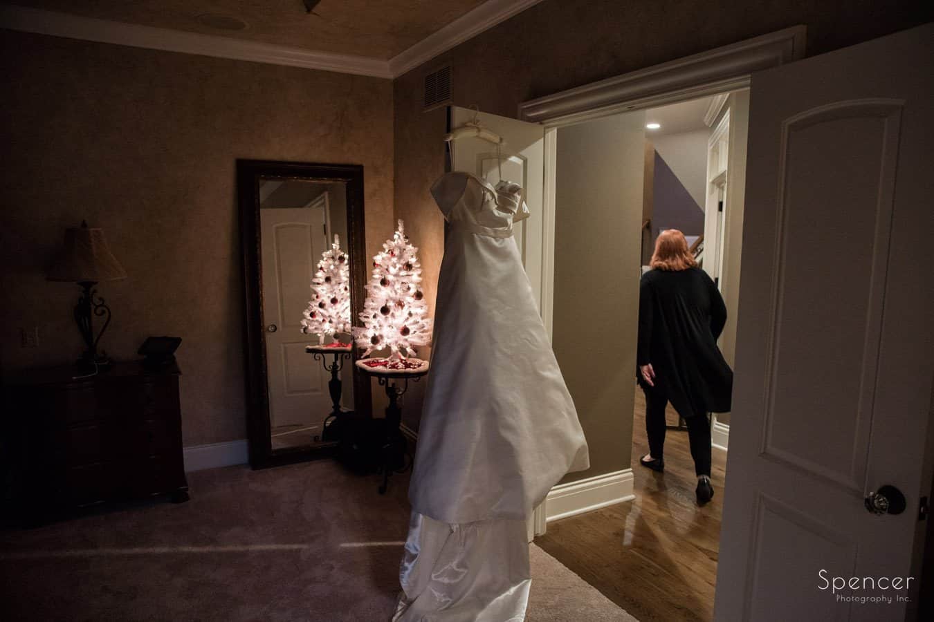  wedding dress haning with christmas tree in background