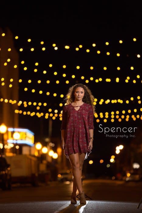 unique senior photos at night with cafe lights