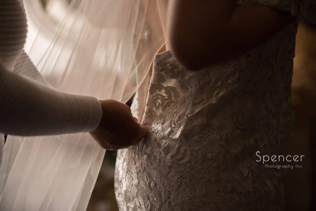 bride zipping up wedding dress at Cleveland Grace Church