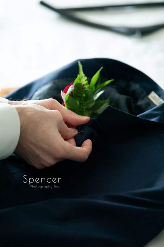 groom pinning on wedding day boutonniére at Avalon Hotel Youngstown