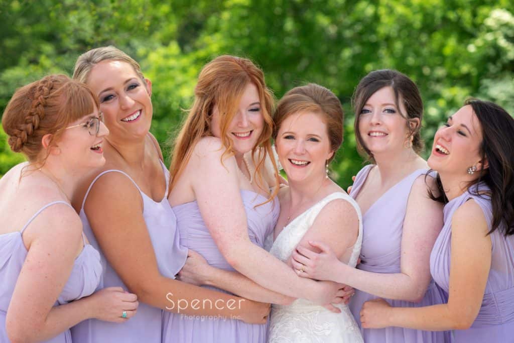 bridesmaids hugging and laughing on wedding day at Cleveland Museum of Art