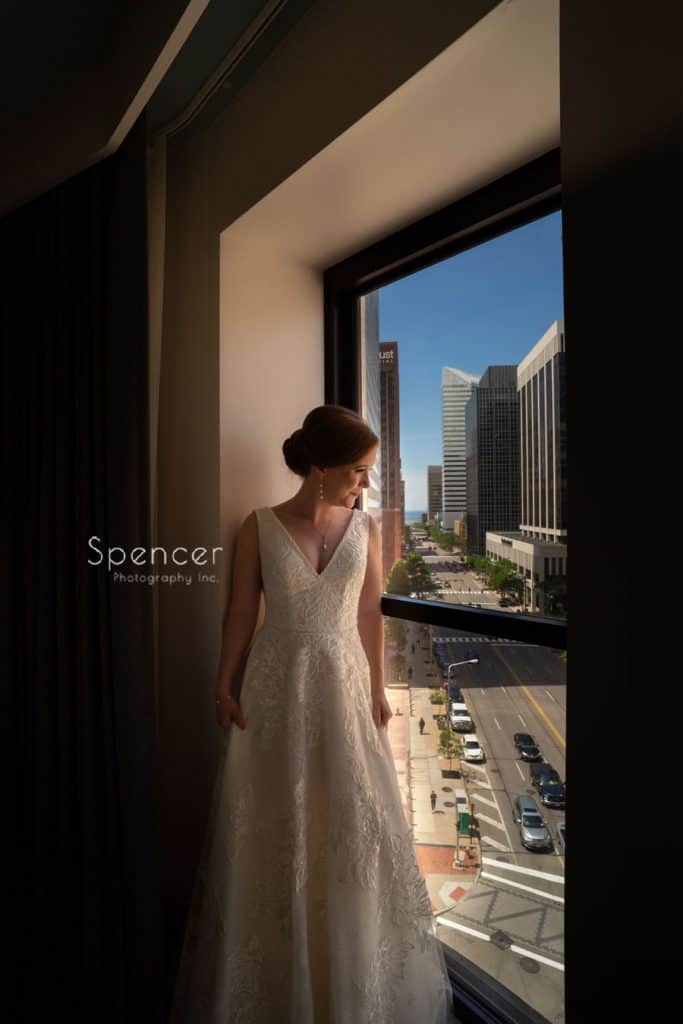 bride looking out window at Kimpton Schofield Hotel in Cleveland