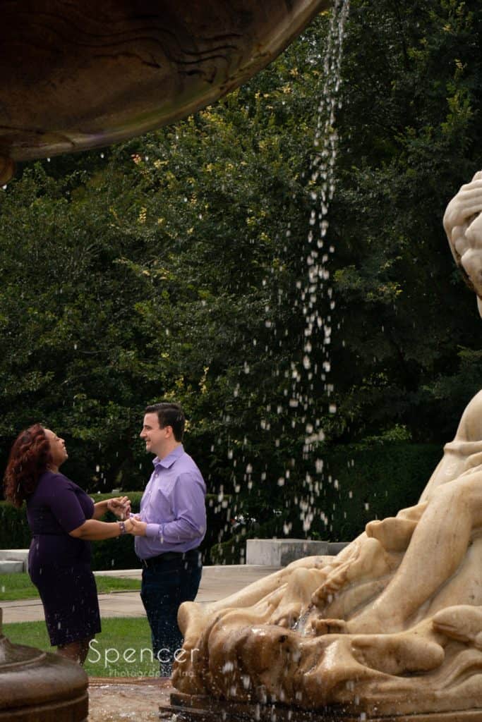 engaged couple laughing by fountain at Cleveland Museum of Art