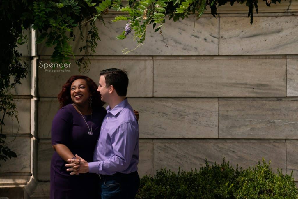 man smiling at woman during engagment pictures at Cleveland Museum of Art