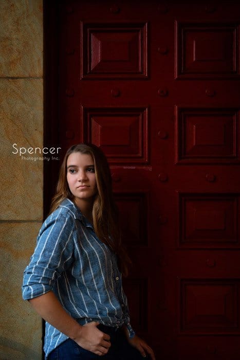 unique senior picture of girl in front of red door