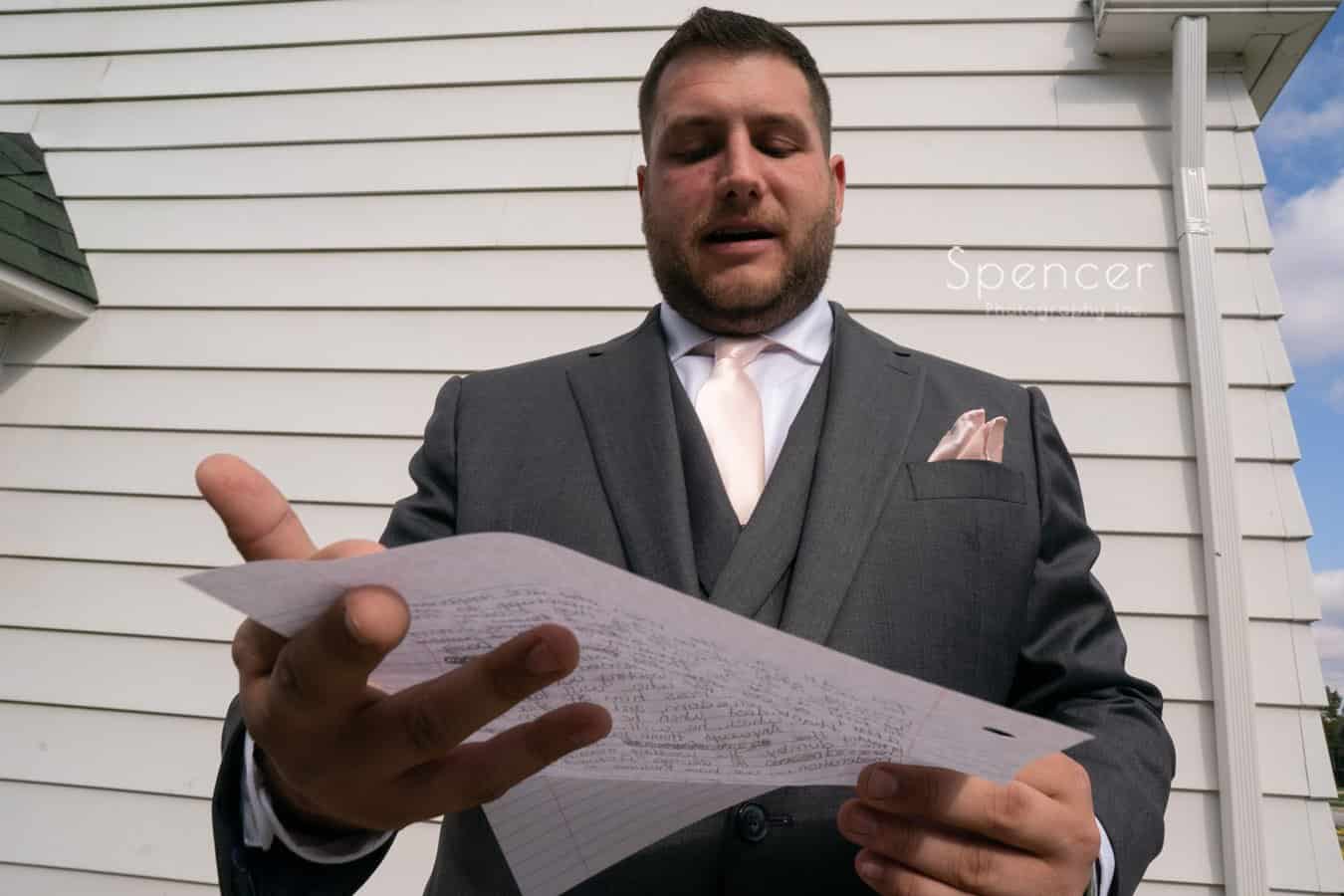 groom reading wedding day letter from bride