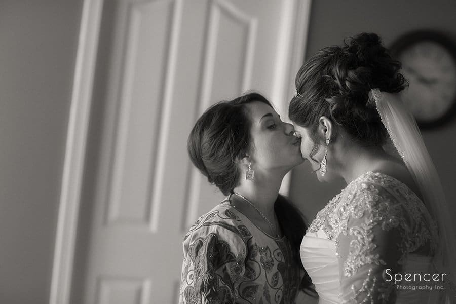 black and white picture of bridesmaid kissing bride