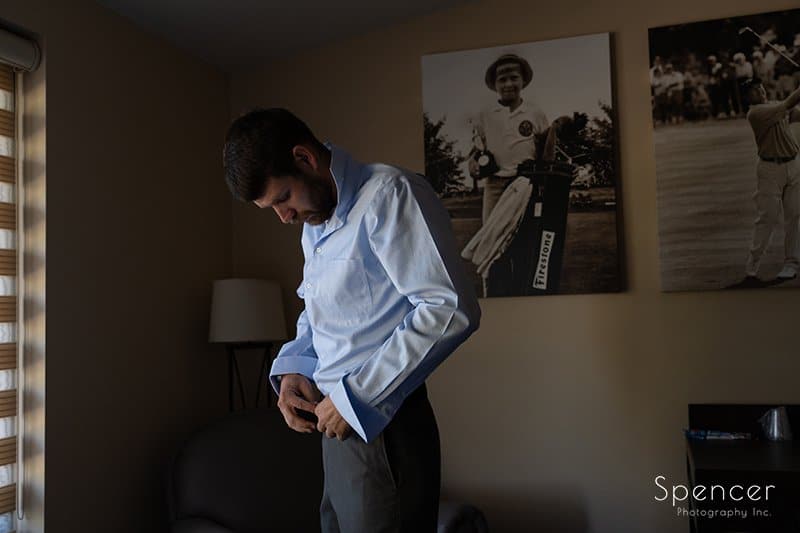 groom dressing in suite at Firestone Country Club