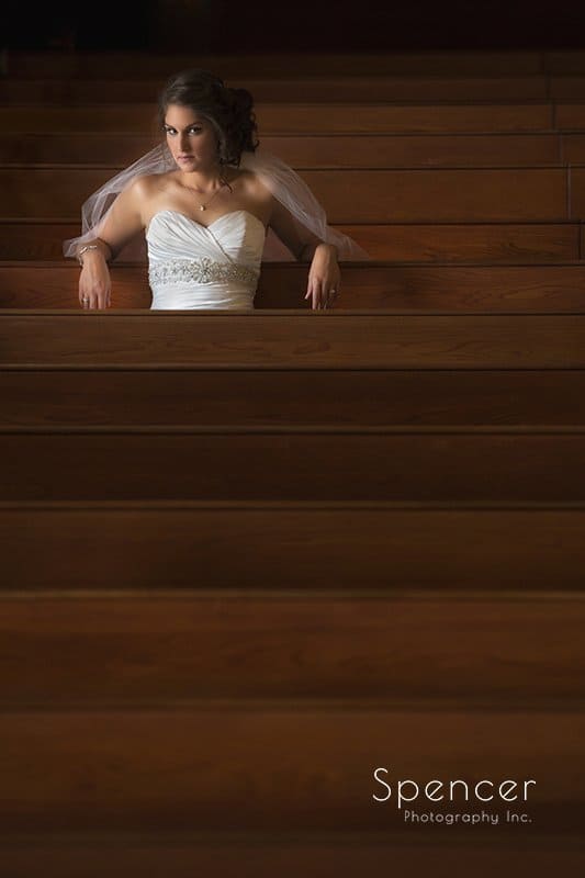 bride sitting in a wedding pew at Church on the Lakes