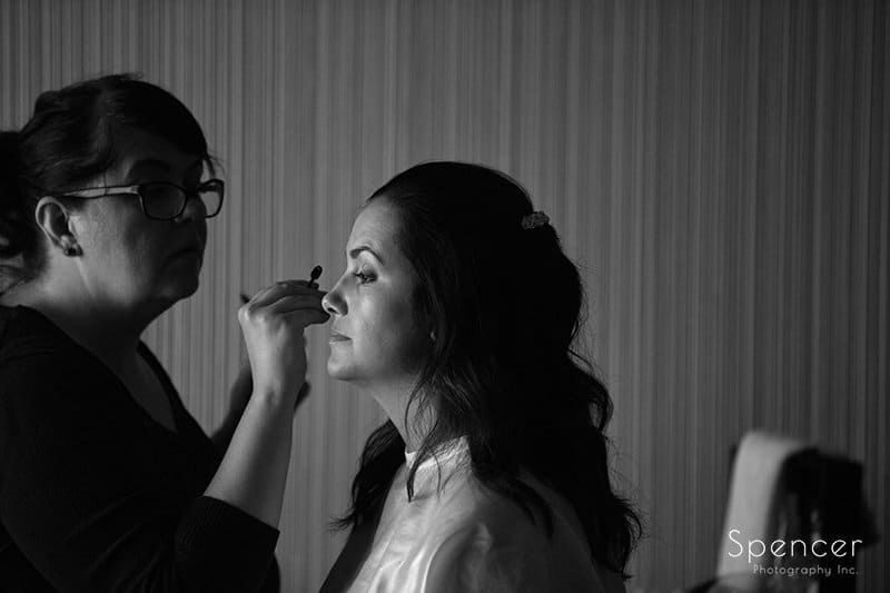 black and white picture of bride getting make-up at Aloft Cleveland