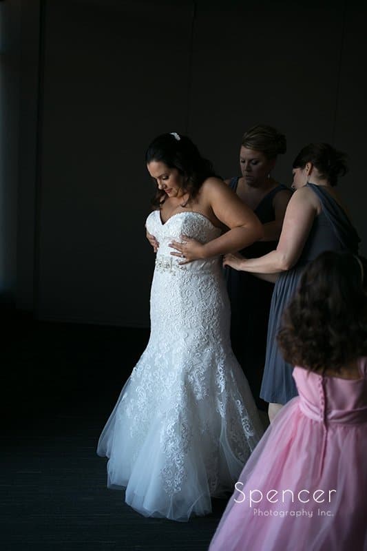 bride putting on wedding dress on wedding day at Aloft Cleveland