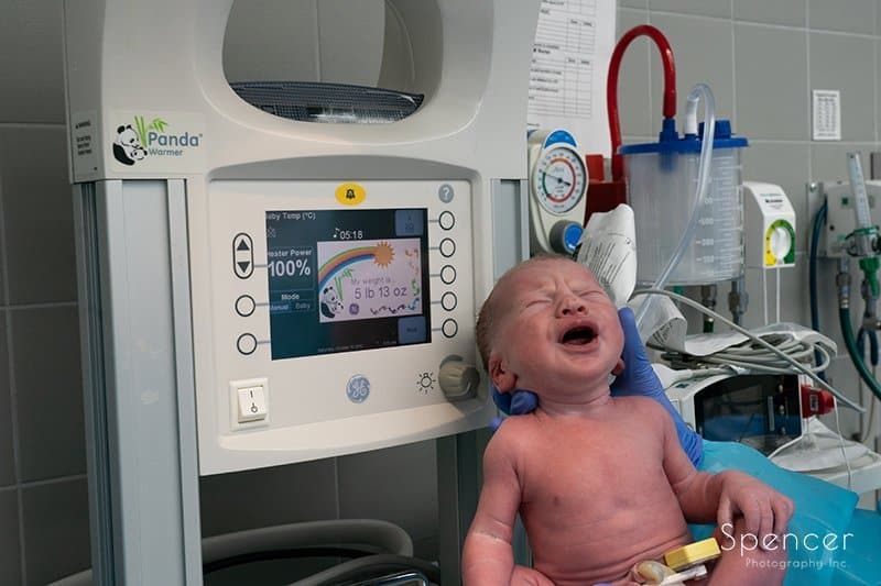 picture of newborn next to monitor :: birth photography