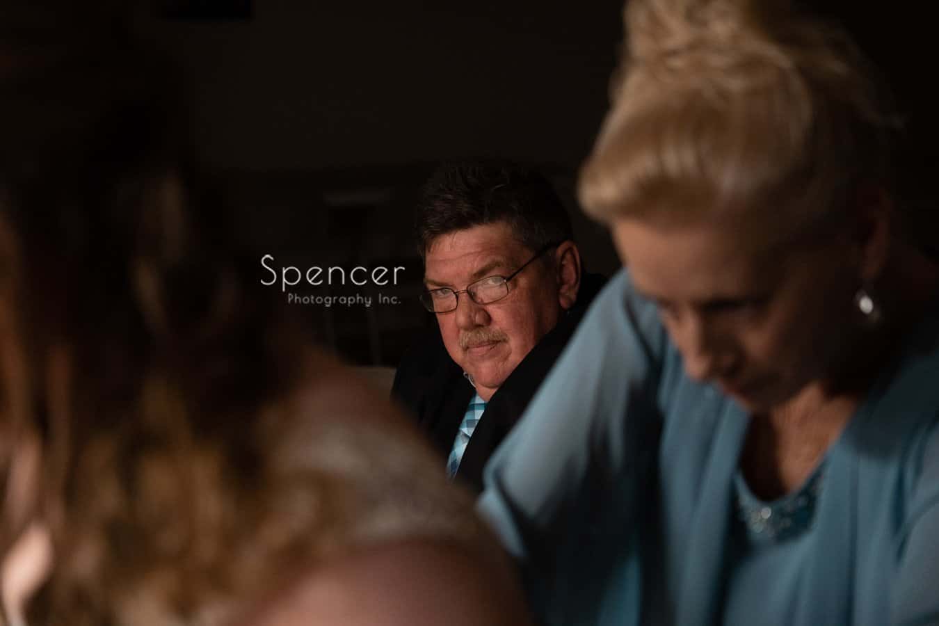 father of bride watching mom help bride