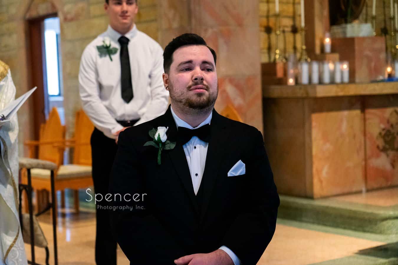 groom watching bride walk down aisle
