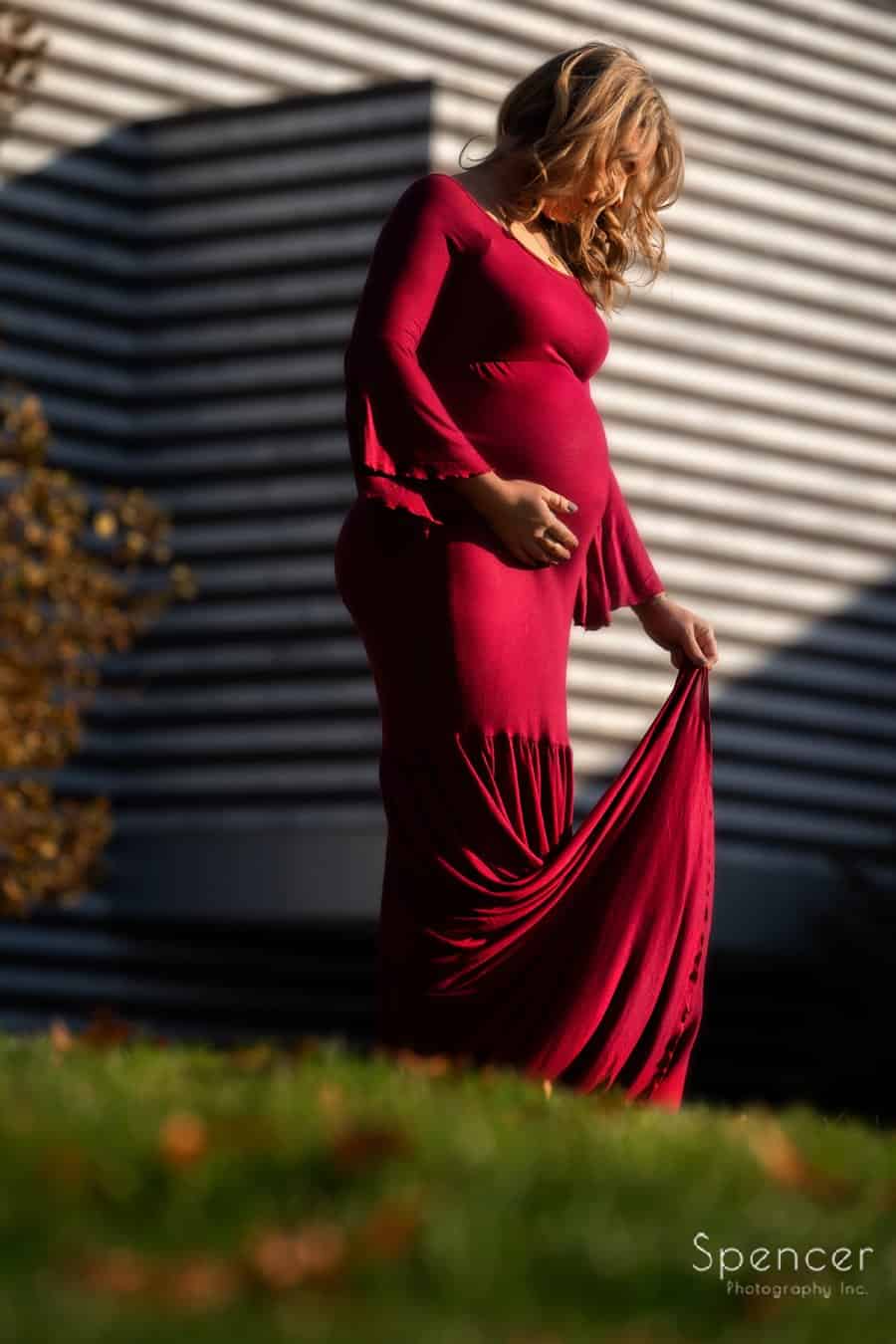 mom adjust dress during maternity pictures at Cleveland Museum of Art