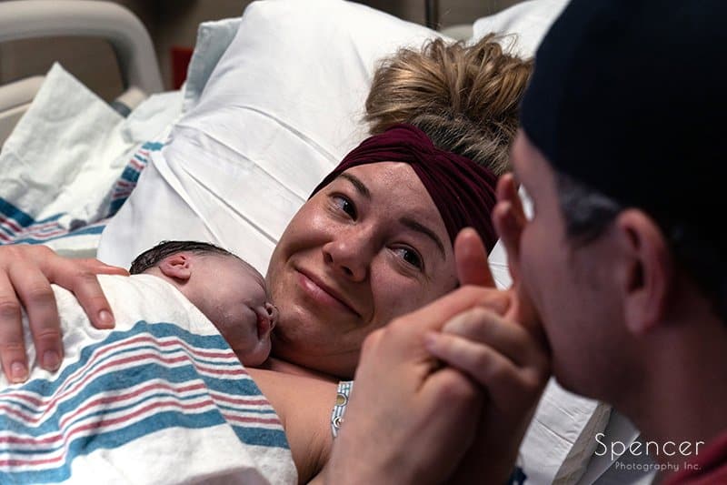  mom smiling at dad after birth of their child