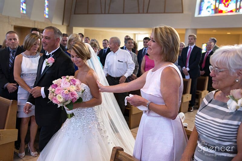  mom reaching out to touch bride as she walks down aisle