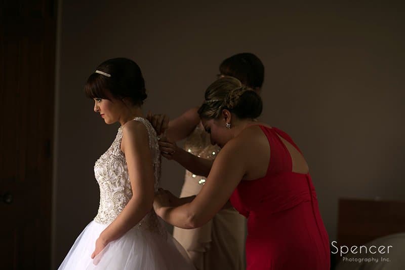 bride putting on wedding dress at Firestone
