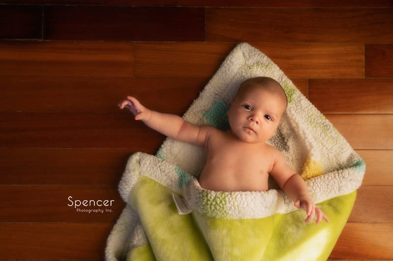 picture of baby with blanket laying on the floor