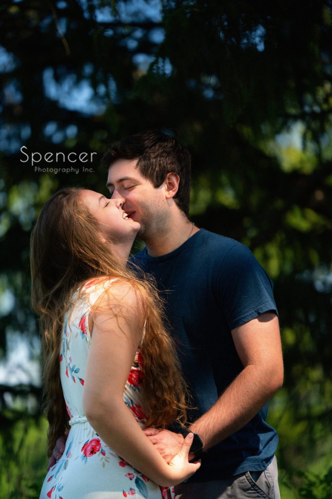 man kissing laughing woman during engagement pictures at Acacia
