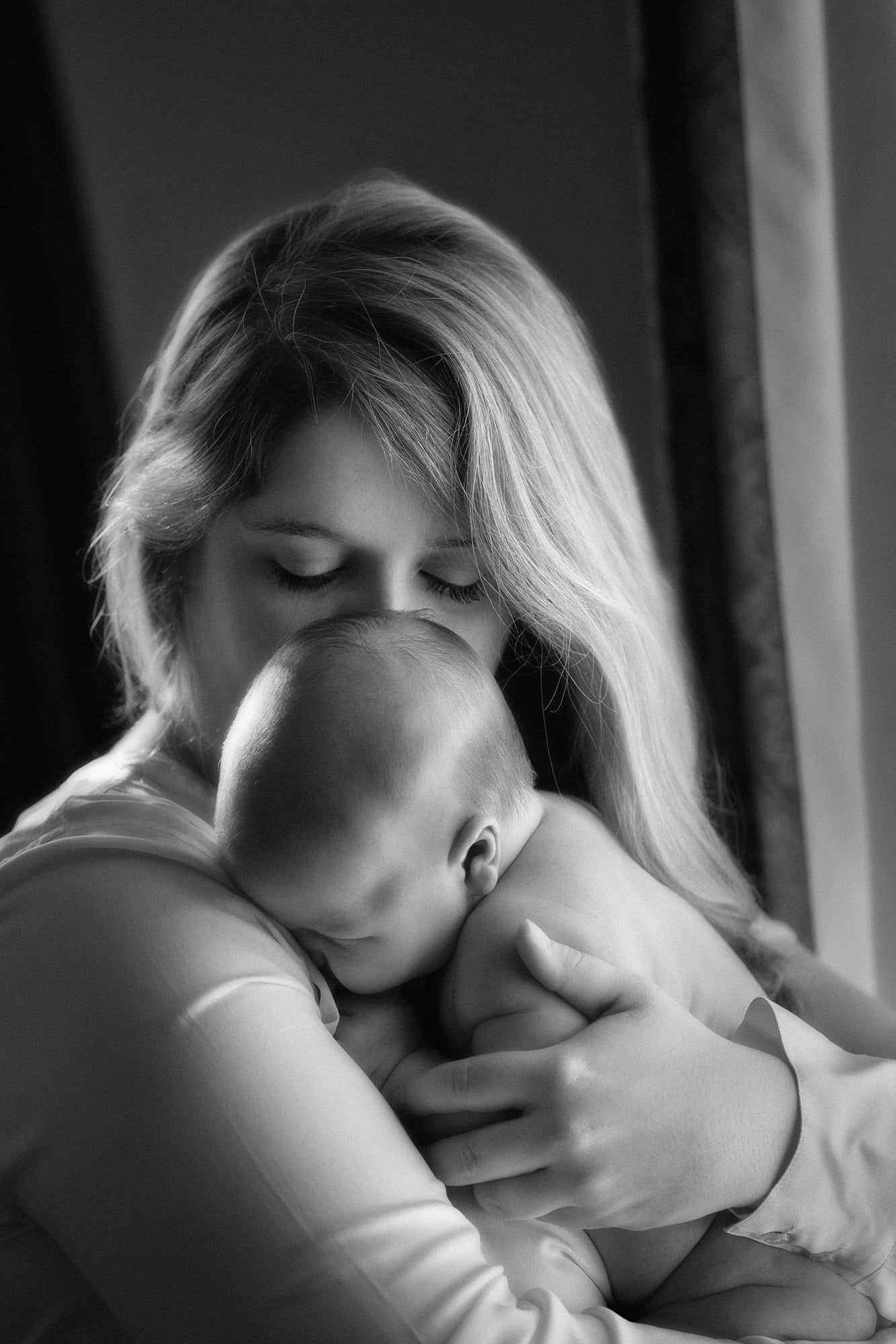 mom hugging baby in black and white picture