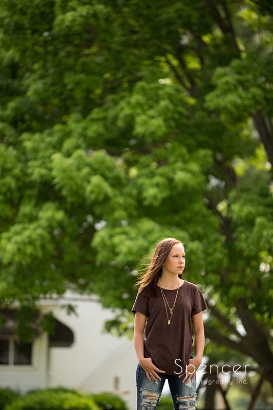senior picture of girl standing in front of tall tree
