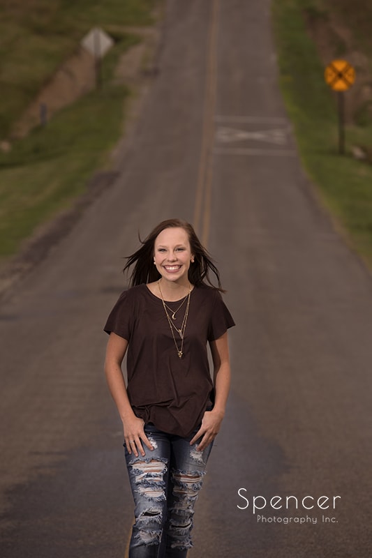 senior picture of girl walking down country road